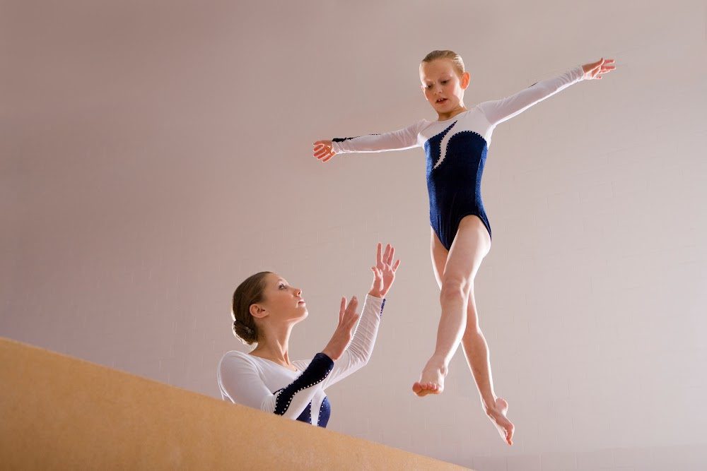 Young girl jumping on balance beam
